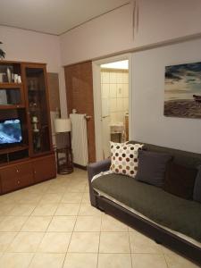 a living room with a couch and a television at Cozy apartment in Piraeus