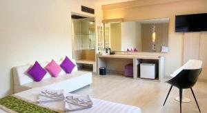 a living room with purple pillows on a couch at Bunjongburi Hotel in Ban Tha Kup