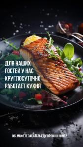 a black plate of food with a piece of fish at Eleon in Almaty