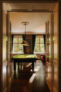 a hallway with a pool table in a room with windows at Villa Titina in Miedzygorze