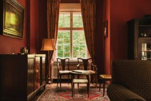 a living room with a table and chairs and a window at Villa Titina in Miedzygorze