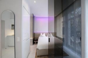 a bedroom with a white bed and a mirror at VISIONAPARTMENTS Gerechtigkeitsgasse - self check-in in Zurich