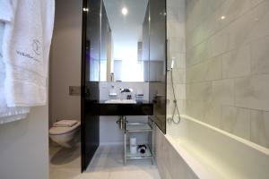 a bathroom with a sink and a toilet and a mirror at VISIONAPARTMENTS Gerechtigkeitsgasse - self check-in in Zurich +81 photos