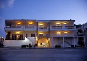 um grande edifício branco com luzes acesas à noite em Filoxenia Hotel em Monemvasia