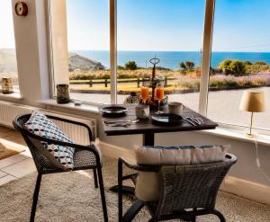 a dining room with a table and chairs and a window at Follies Garden Room in Dungarvan