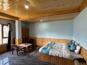 a bedroom with a bed and a wooden ceiling at Hill Ice Guesthouse & Cafe - Mountain View & Balcony, Tosh in Tosh