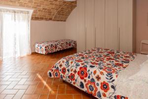 a bedroom with a bed with a floral comforter at La Rusacca Pacentro in Pacentro