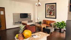 a living room with a couch and a tv at Victoria Hotel Apartment in Addis Ababa