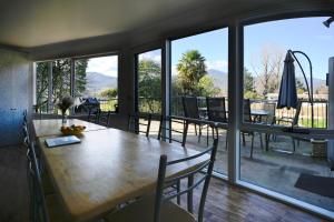 a dining room with a table and a large window at Alpzview Guesthouse in Tawonga