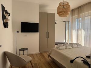 a bedroom with a bed with a chair and a television at Alta Terrace - Warm Apartment with Large Terrace in Seriate