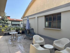 a patio with chairs and a table and an umbrella at Alta Terrace - Warm Apartment with Large Terrace in Seriate