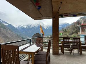 a restaurant with tables and chairs and a view of mountains at Hill Ice Guesthouse & Cafe - Mountain View & Balcony, Tosh in Tosh