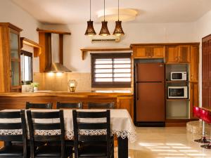 a kitchen with a table with chairs and a refrigerator at בית ההר - וילה למשפחות עם בריכה פרטית in Rama