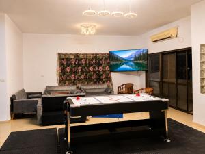 a living room with a ping pong table at בית ההר - וילה למשפחות עם בריכה פרטית in Rama