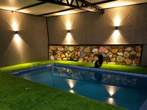 a swimming pool in a house with lights on it at בית ההר - וילה למשפחות עם בריכה פרטית in Rama