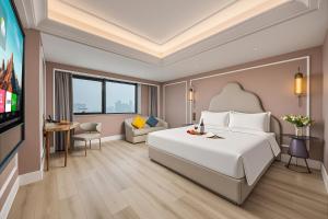 a hotel room with a large bed and a tv at Mercure Hefei Huaihe Road in Hefei