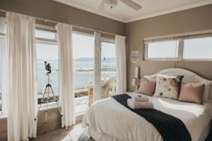 a bedroom with a bed with a view of the ocean at La Melamire On the Rocks Bed & Breakfast in Gansbaai