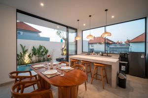 a kitchen and dining room with a table and chairs at Snuggy Shack Villas in Munggu