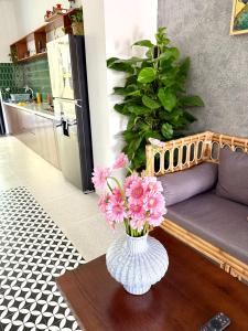a vase filled with pink flowers sitting on a table at An Bang Chic Villa Nguyên Căn in Tân Thành (1)