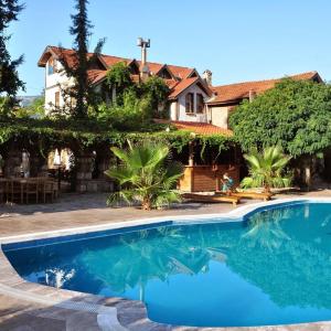 a swimming pool in front of a house at Olympos Koyevi Pension in Olympos