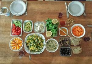 une table en bois avec des bols de différents types de denrées alimentaires dans l'établissement Olympos Koyevi Pension, à Olympos