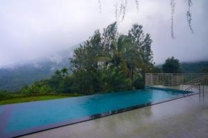 a swimming pool with a view of a mountain at Mountree Munnar by Kondody Hotels in Anachal