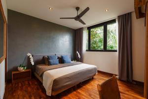 a bedroom with a bed and a ceiling fan at Villa Pakuk by Alfred in Bali in Canggu +44 photos