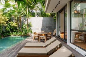 an outdoor patio with a table and a swimming pool at Villa Pakuk by Alfred in Bali in Canggu