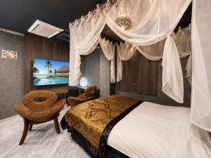 a bedroom with a canopy bed and a television at Hotel BaliBali 仙台 in Kōtōdaitōri