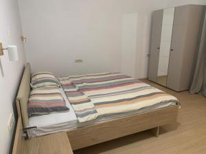 a bed with a striped blanket on it in a room at Amor in Klake