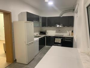 a kitchen with a white refrigerator and black cabinets at Amor in Klake