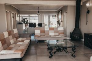 a living room with two couches and a coffee table at La Melamire On the Rocks Bed & Breakfast in Gansbaai