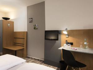 a hotel room with a bed and a desk and a tv at ibis Styles Hotel Gelsenkirchen in Gelsenkirchen +47 photos