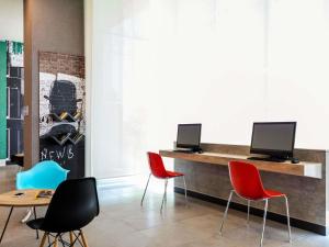 a lobby with chairs and a desk with a computer at Ibis Mexico Tlalnepantla in Mexico City