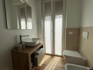 a bathroom with a sink and a toilet and a mirror at Alta Terrace - Warm Apartment with Large Terrace in Seriate +8 photos