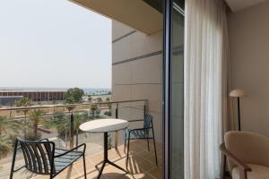 a room with a balcony with chairs and a table at Catalonia Barcelona Beach in Barcelona +42 photos