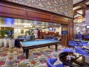 a pool table in a room with blue chairs at Rixos President Hotel Astana in Astana