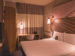 a hotel room with a bed and a desk at ibis Carlos Barbosa in Carlos Barbosa