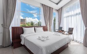 a bedroom with a bed with a large window at Sandy Residence Sihanoukville in Sihanoukville +69 photos
