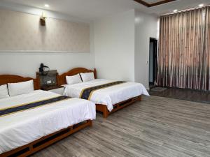 a hotel room with two beds and a window at Khách sạn CƯỜNG THÀNH in Thái Nguyên