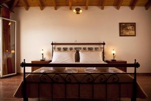 a bedroom with a large bed with two lamps at Filoxenia Hotel in Monemvasia