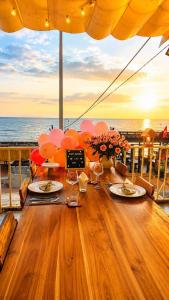 a table with balloons and wine glasses on a deck at Cham Charm Apartment Hotel Mui Ne in Mui Ne