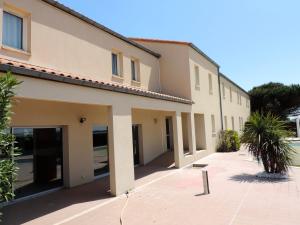 a building with its doors open on a sidewalk at Logis Hôtel L'Air Marin in Yves