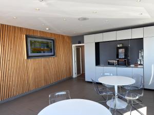 a room with a table and chairs and a kitchen at Måby Park Hotel Arlanda in Arlanda