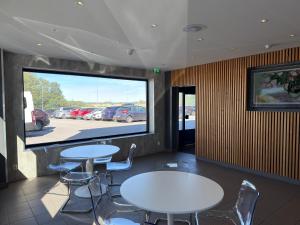 two tables and chairs in a restaurant with a large window at Måby Park Hotel Arlanda in Arlanda