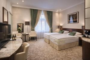 a hotel room with two beds and a television at Hotel Grand in Český Krumlov