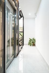 a hallway with glass doors and a potted plant at Aura Retreat Boutique Hotel Hanoi in Hanoi
