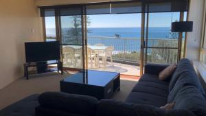 a living room with a couch and a view of the ocean at Sea Eagles Unit 9 in Caloundra