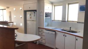 a kitchen with a sink and a refrigerator at Sea Eagles Unit 9 in Caloundra +7 photos