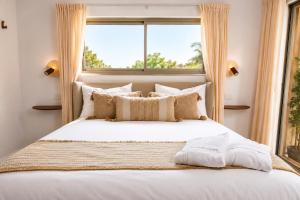 a bedroom with a large white bed with a window at סוויטת דרים רויאל - סוויטה חלומית עם אמבט ספא מפנק ונוף מדהים in ‘Ein Ya‘aqov